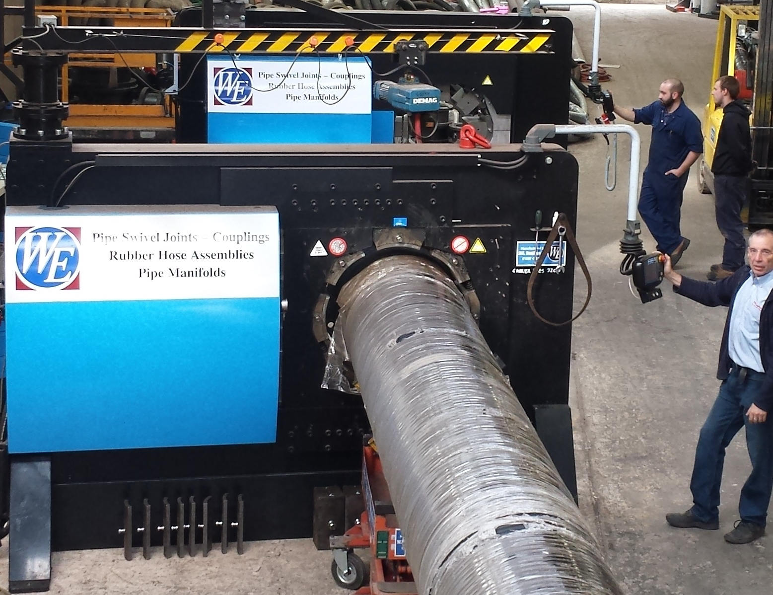 These are two large bore crimping machines with engineers using them.